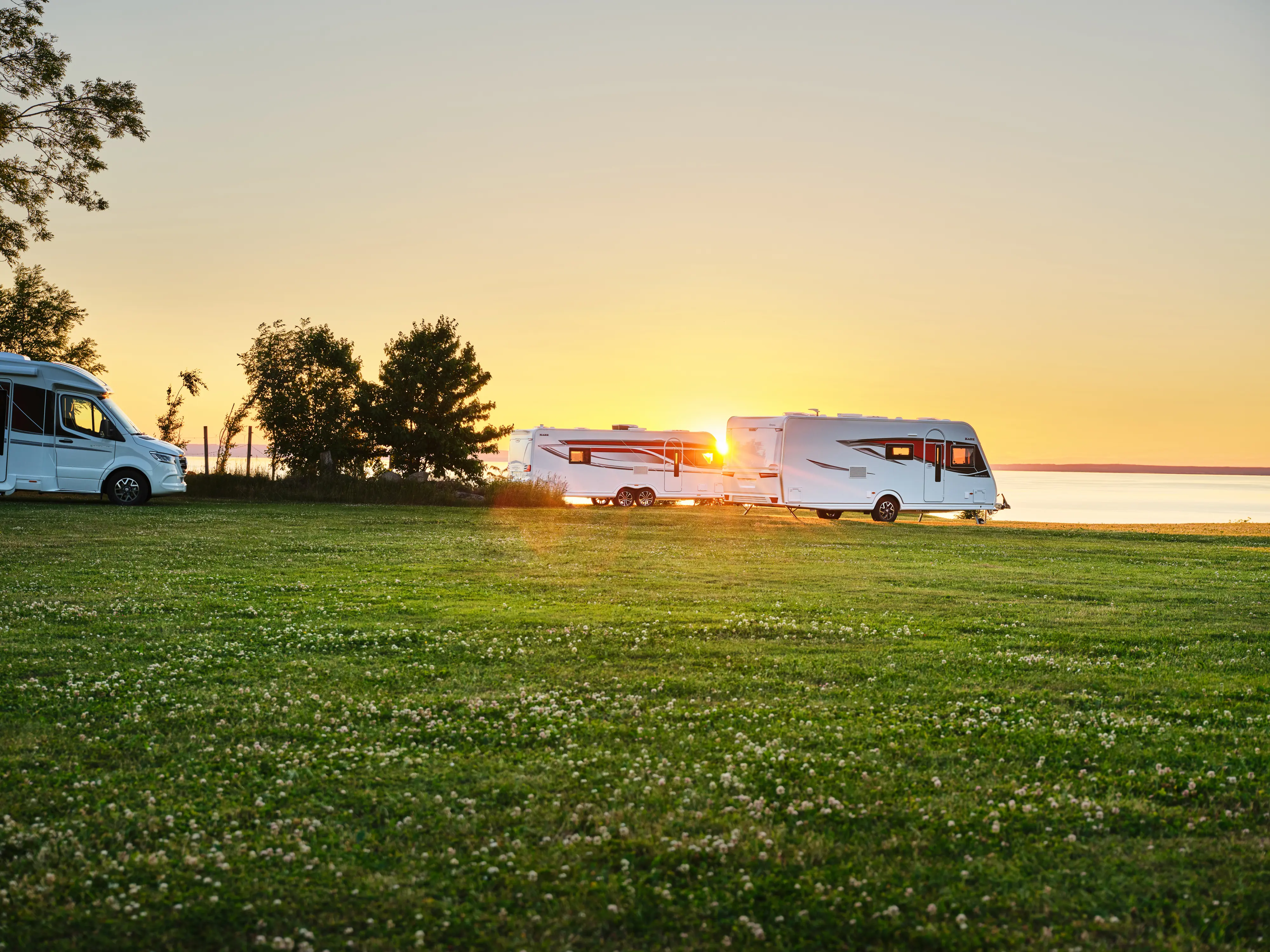 Kabe husbil och husvagn i solnedgång